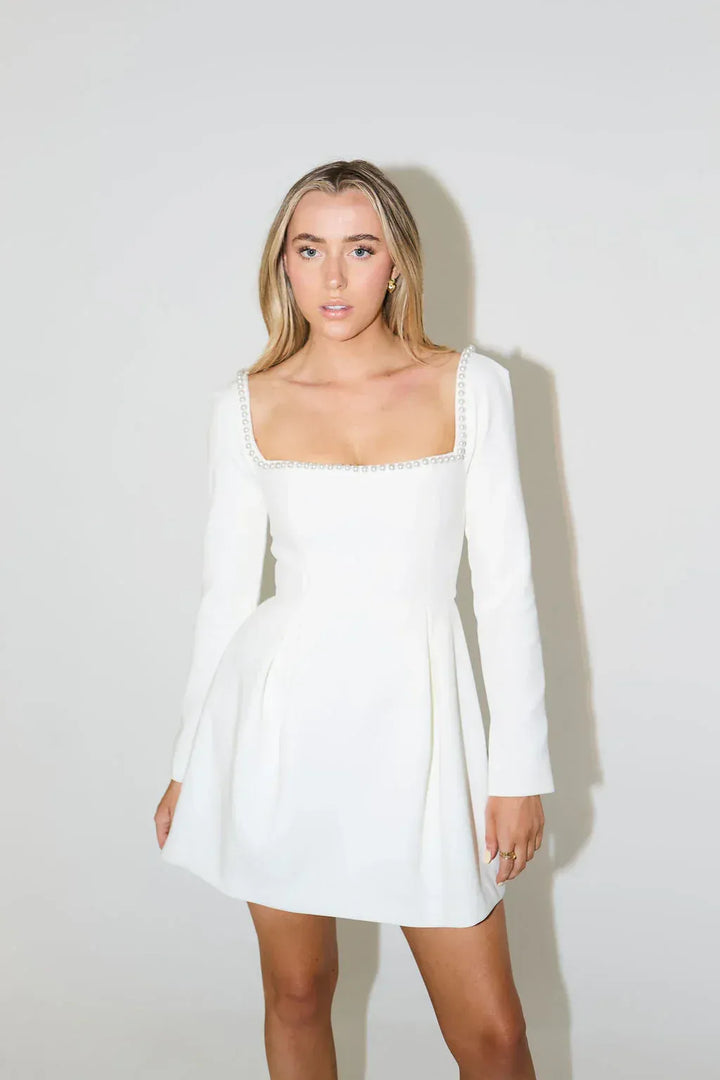 Sophisticated women's long sleeve mini dress with elegant pearl trim, ideal for cocktail & evening wear.