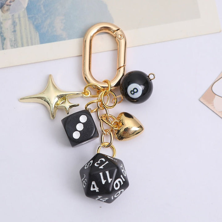 Close-up of a women's lucky charm keychain, featuring a gold-tone dice and vibrant multi-color beads, metal.