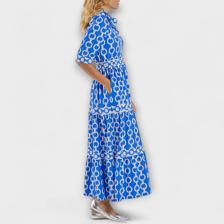 Model wearing an elegant women's midi summer dress with a striking chain pattern and fashionable tiered skirt.