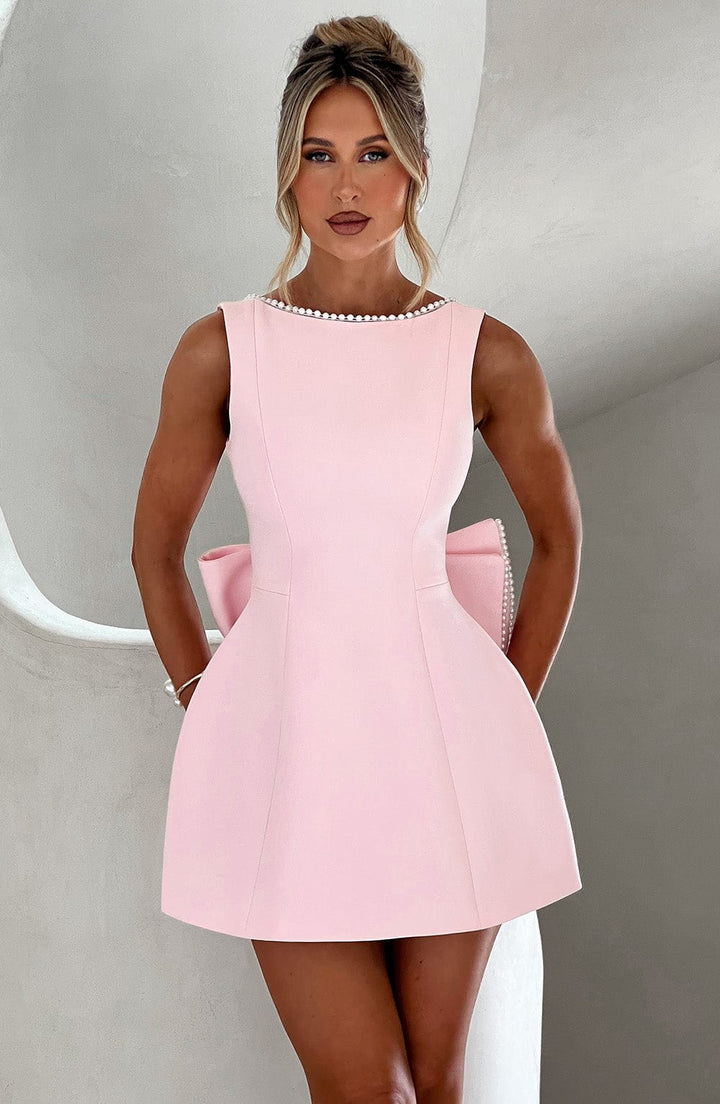 Elegant women's mini dress with pearl trim and a statement bow back.
