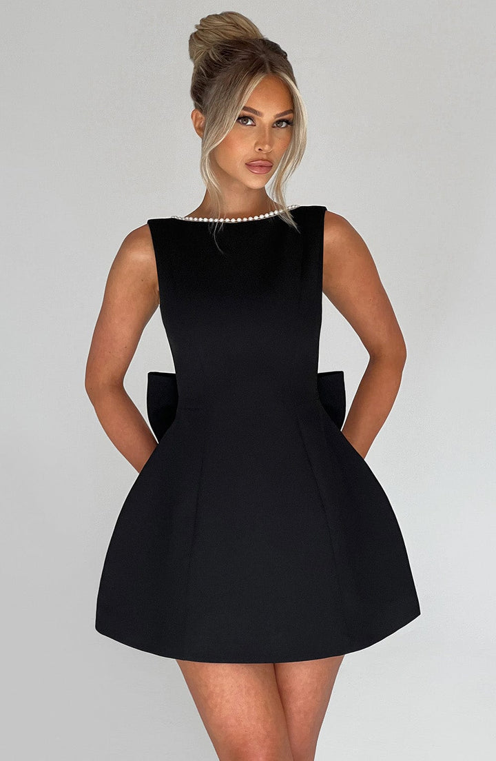 Stylish party mini dress for women, featuring pearl trim and a large bow back.