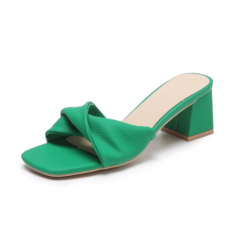 Fashionable women's open-toe mule sandals with a block heel and elegant twisted strap. Comfortable slip-on heels.