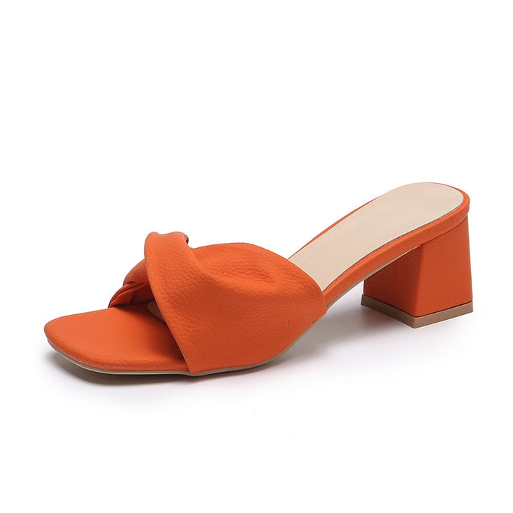 Women's elegant twisted strap mule sandals. Stylish block heel slip-on heels with an open toe for comfort.
