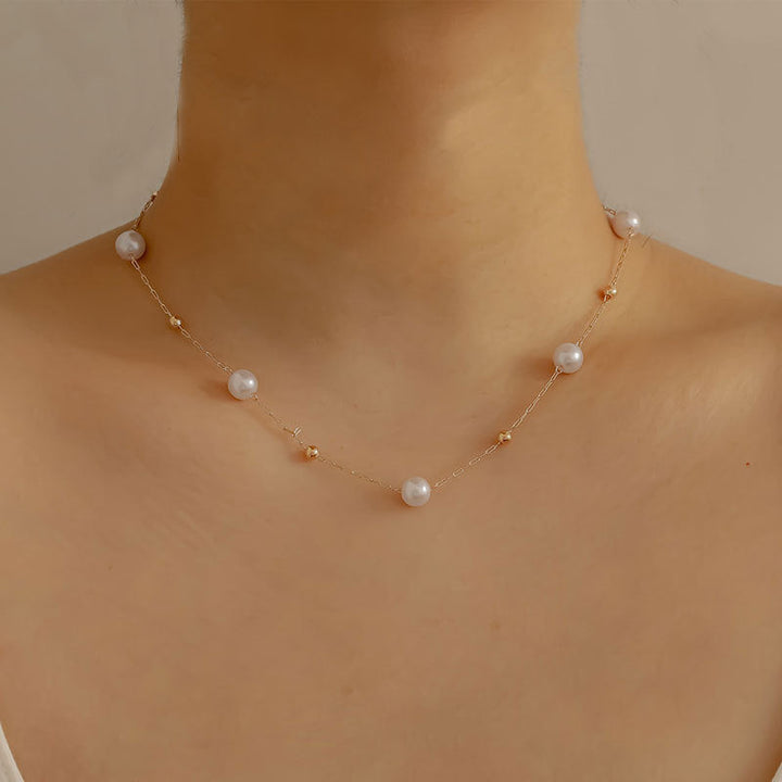 Women's gold chain necklace featuring lustrous imitation pearls, a sophisticated and adjustable jewelry piece.