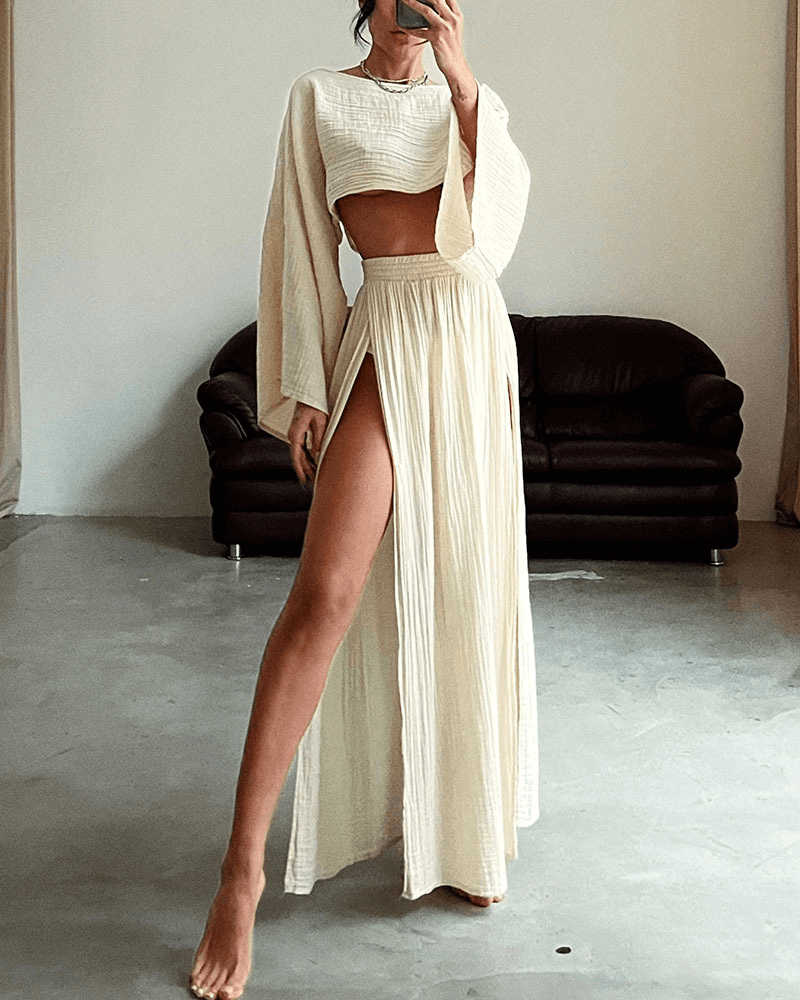 Model wearing elegant women's off-shoulder long sleeve top and high-waist maxi skirt set with side slit, ideal evening wear.