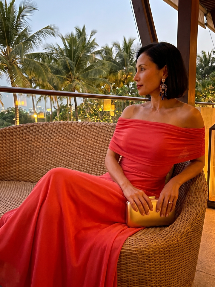 Full length view of a women's elegant off-shoulder midi dress, draped for a sophisticated evening look.
