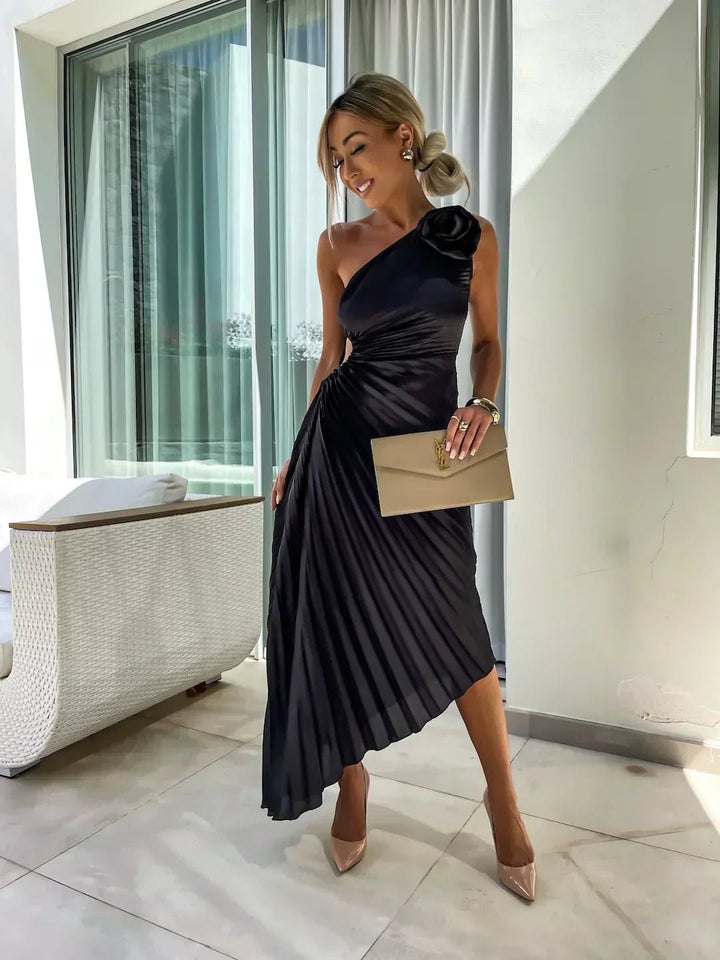Women's elegant pleated maxi dress, one shoulder style, adorned with beautiful floral detail.