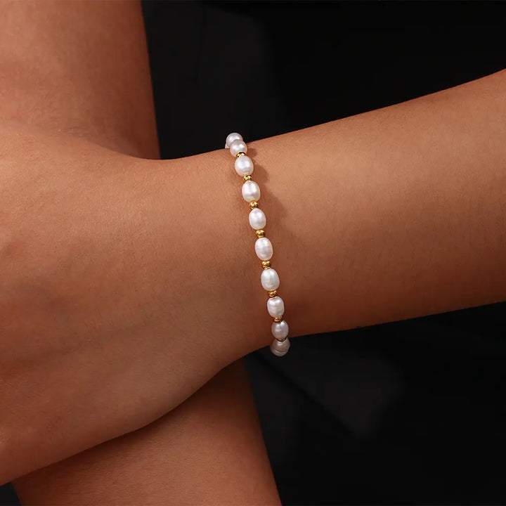 Beautiful women's gold bracelet adorned with luminous pearls. Timeless elegant jewelry gift.