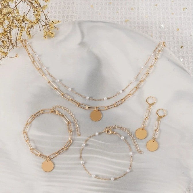 Close-up of a women's layered pearl and gold chain necklace, a stunning piece from an elegant jewelry set.