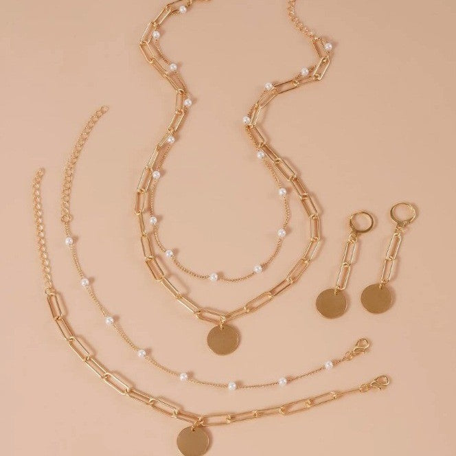 Delicate pearl beads and golden link chain women's jewelry set, an elegant layered necklace and matching accessories.