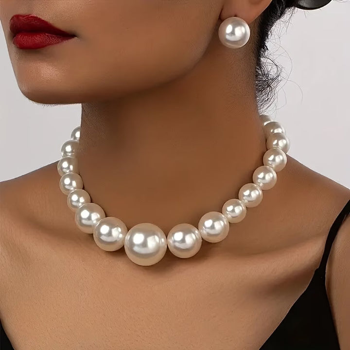 Elegant women's pearl necklace and matching drop earrings set. Timeless classic jewelry accessory for special occasions.