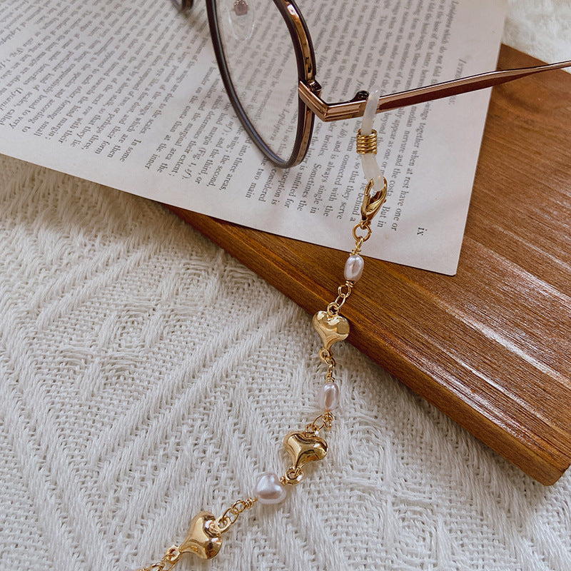 Close-up of elegant women's pearl necklace featuring delicate gold chain and lustrous pearl accents.