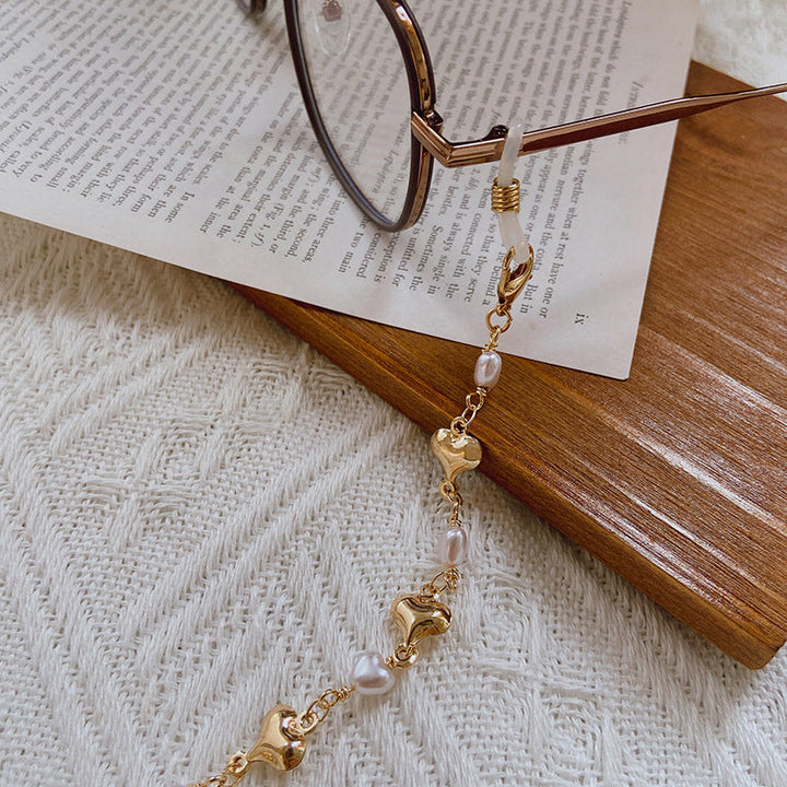 Close-up of elegant women's pearl necklace featuring delicate gold chain and lustrous pearl accents.