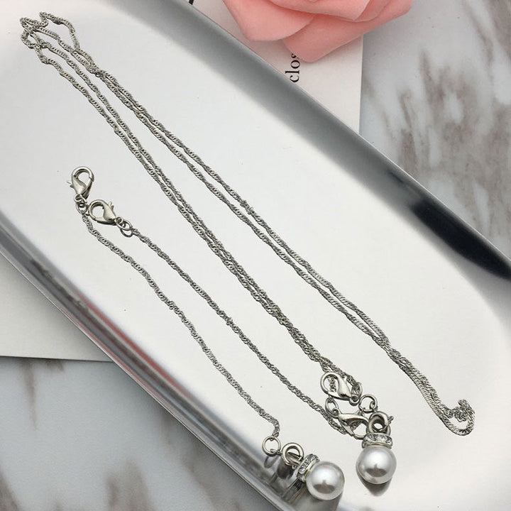 Elegant women's pearl pendant necklace. Features a delicate pearl, silver chain, and gold accent. Classic style women's jewelry.