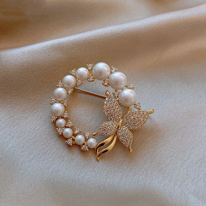 Sparkling rhinestone and delicate pearl butterfly pin for women, an elegant jewelry accessory.