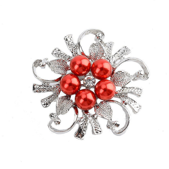 Close-up of a glamorous pearl and gold-tone floral brooch, a chic accessory for women's formal wear.