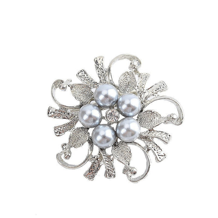 Sophisticated women's pearl brooch pinned on a dark blazer, an elegant floral jewelry accessory.