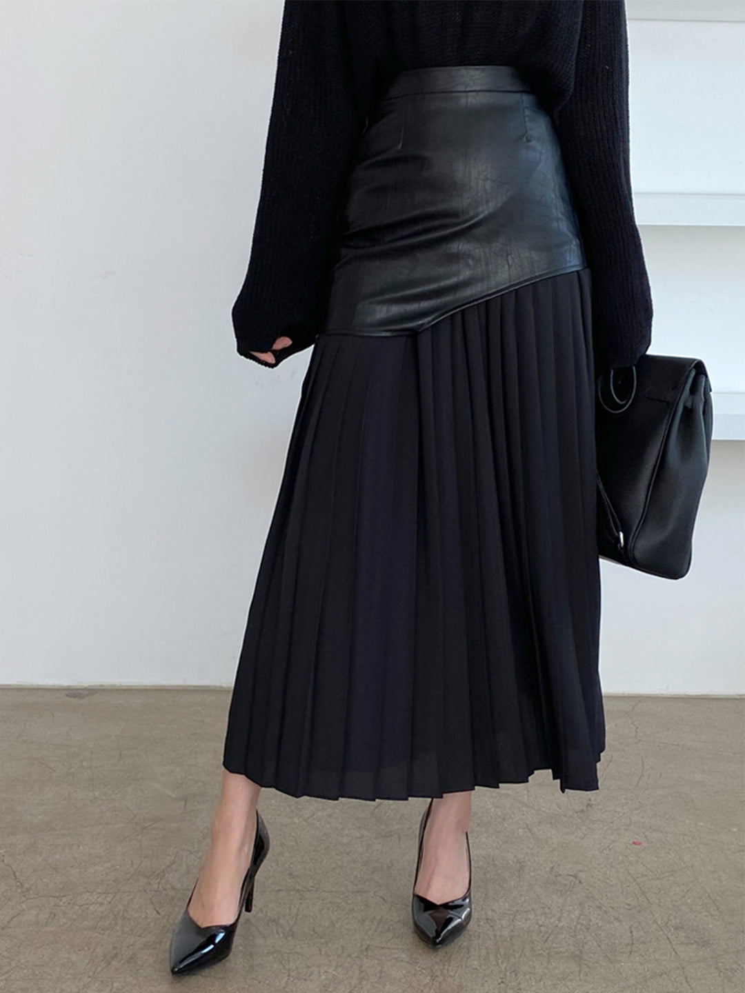 Chic women's high-waisted pleated midi skirt, featuring an asymmetrical hem for a modern elegant look.