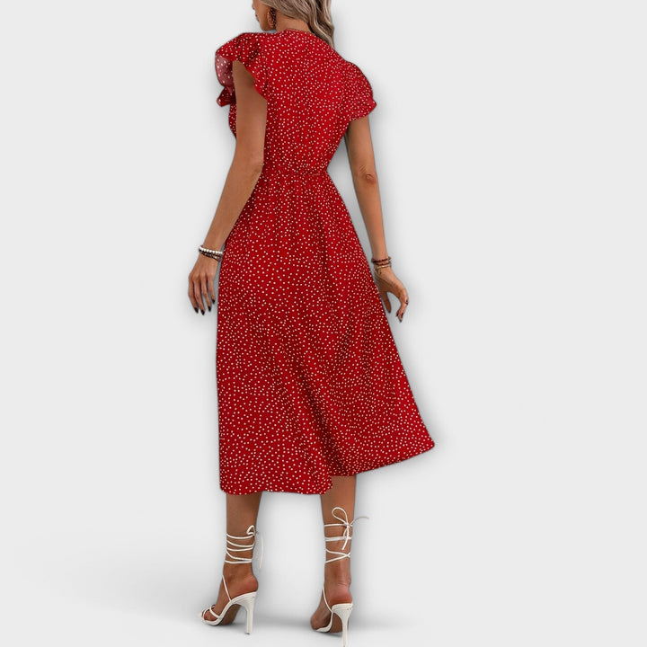 Woman in elegant polka dot A-line V-neck dress outdoors, capturing a chic summer fashion look.