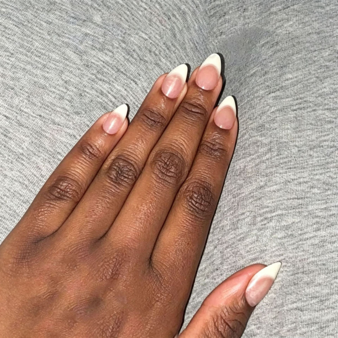 Elegant women's press-on nail art stickers in nude & white almond designs. Salon quality DIY manicure.