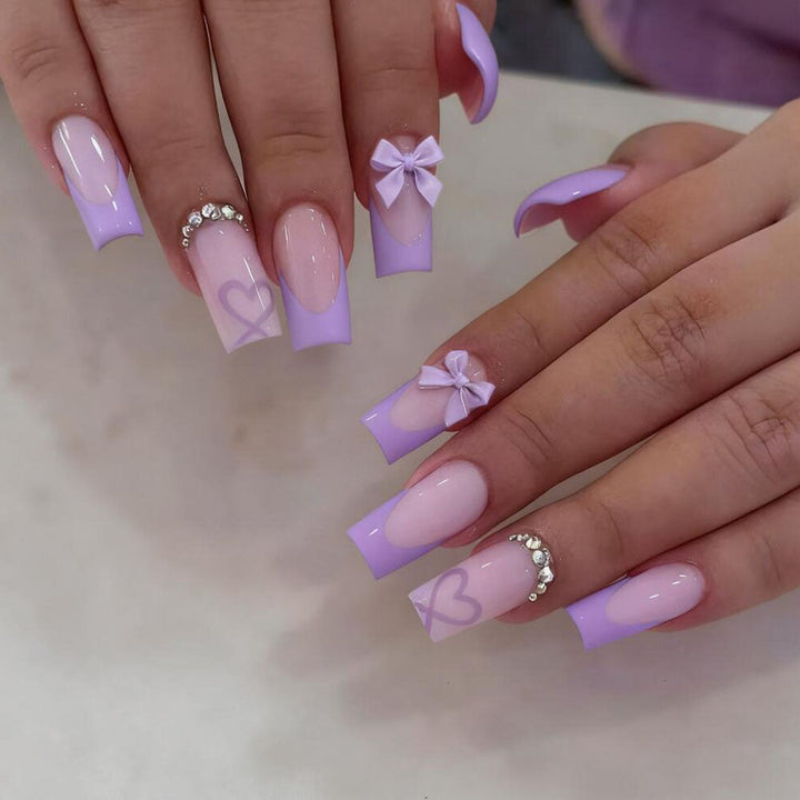 Quick-apply false nails featuring a stylish black tip, delicate bows, and cute heart nail art.