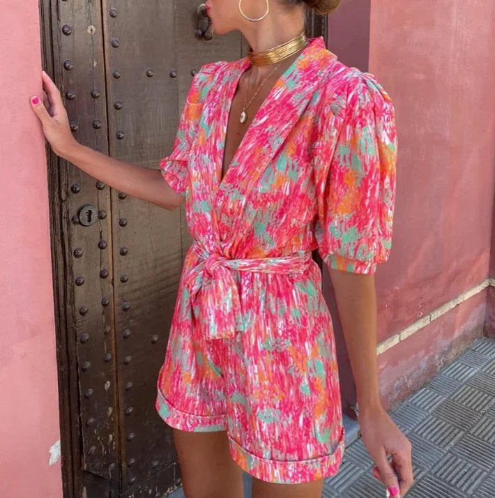 Full-length view of a women's short puff sleeve romper with belt, a chic choice for any special event.