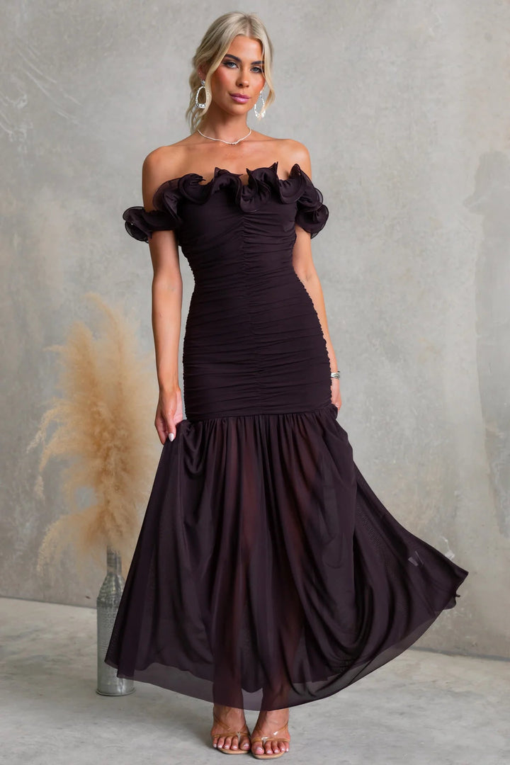 Full length shot of a woman in a formal ruffled off-shoulder maxi dress, perfect for wedding guest attire.