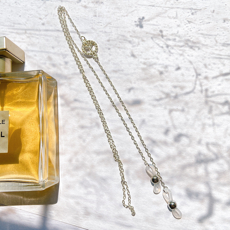 Close-up of a sparkling filigree peace sign pendant on a delicate silver necklace for women, elegant style.