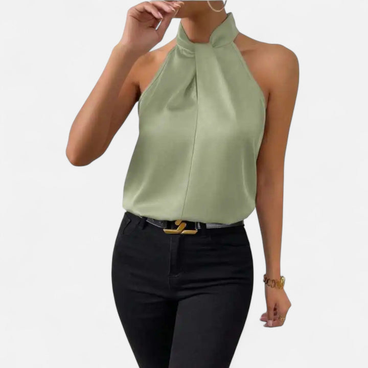 Model in a professional setting, wearing a women's sleeveless twisted neck blouse for a modern office outfit.