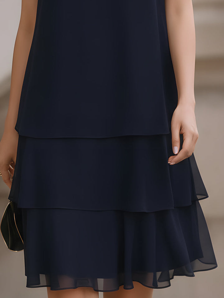 Chic navy blue women's tiered shift dress, a versatile and elegant sleeveless design for various occasions.