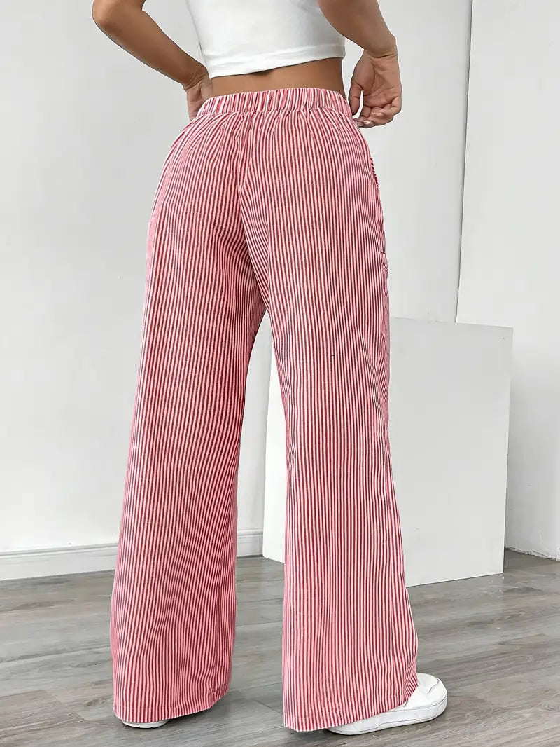Women's elegant striped wide-leg pants flowing gently, featuring stylish pockets.