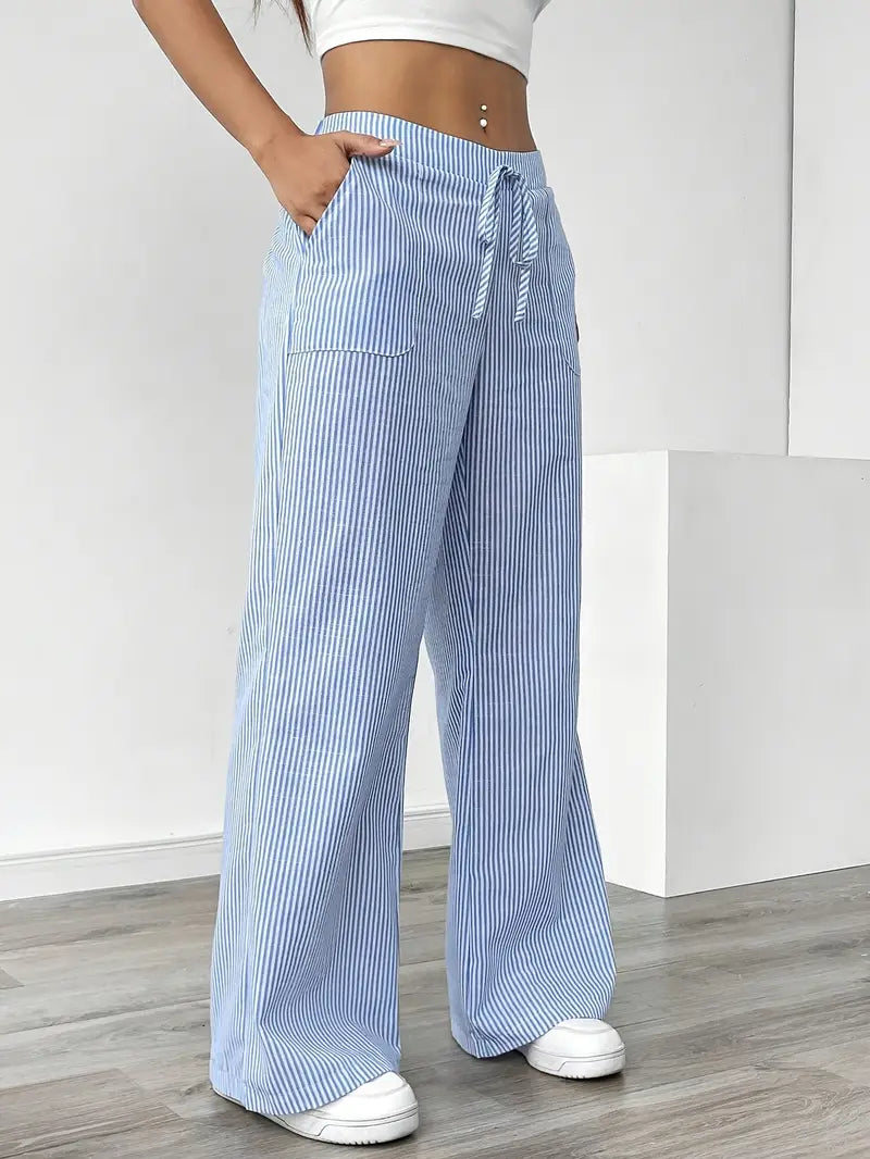 Elegant women's striped trousers with pockets, styled for a sophisticated spring look.