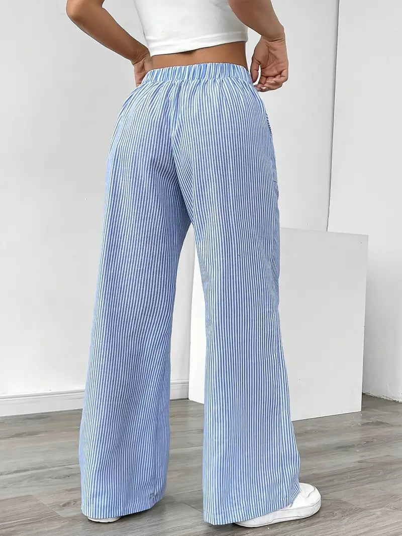 Women's striped wide-leg pants with pockets, shown in a walking pose to emphasize flow.