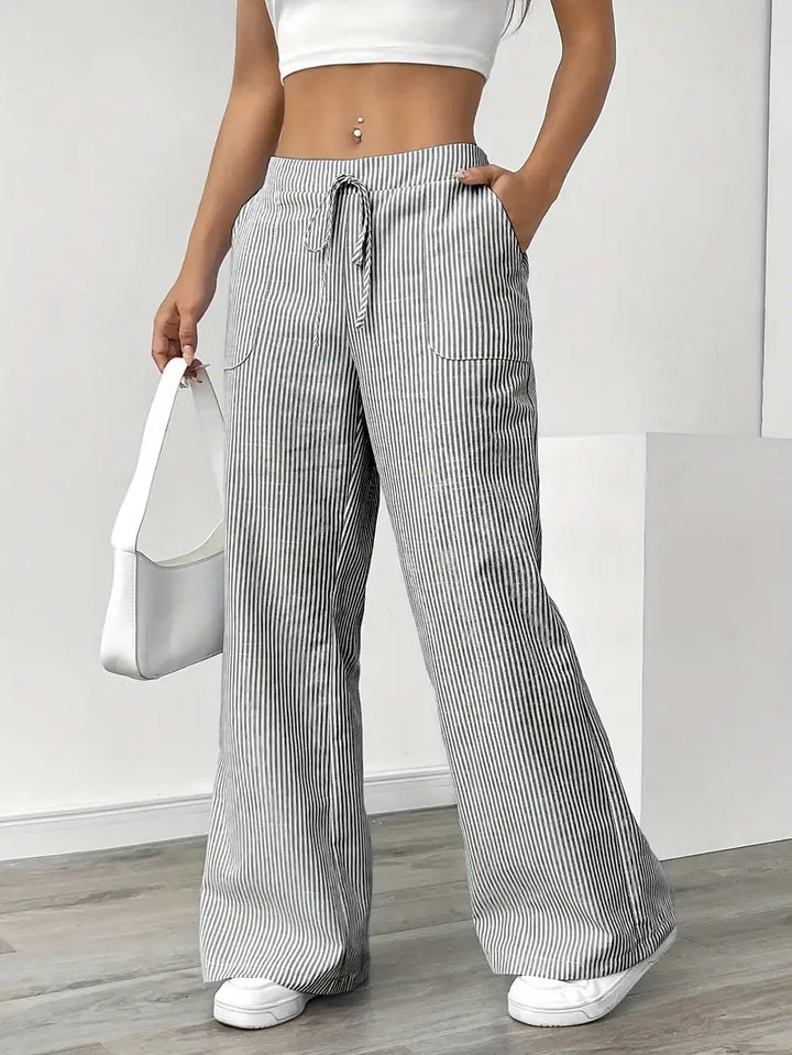 Side view of women's elegant striped wide-leg pants with functional pockets.