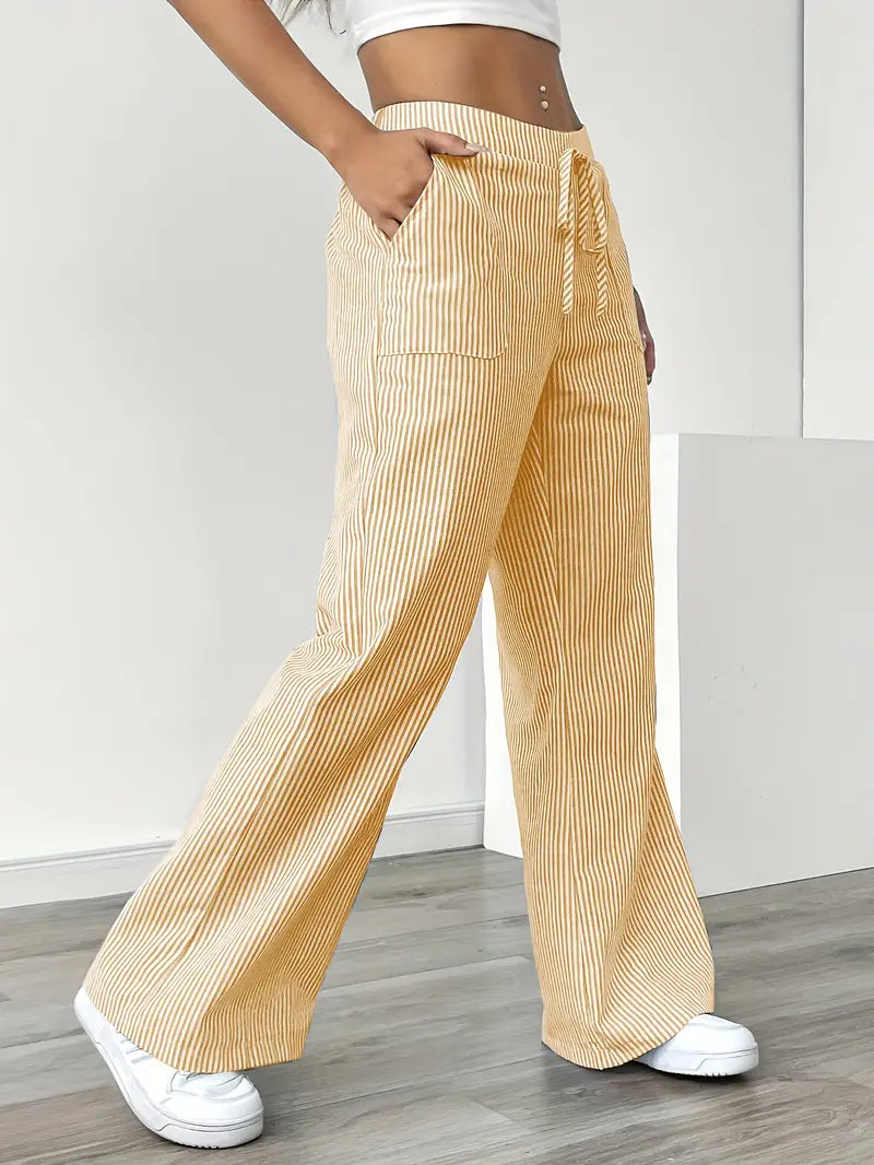 Close-up of elegant striped fabric on women's high-waist pants with visible pockets.