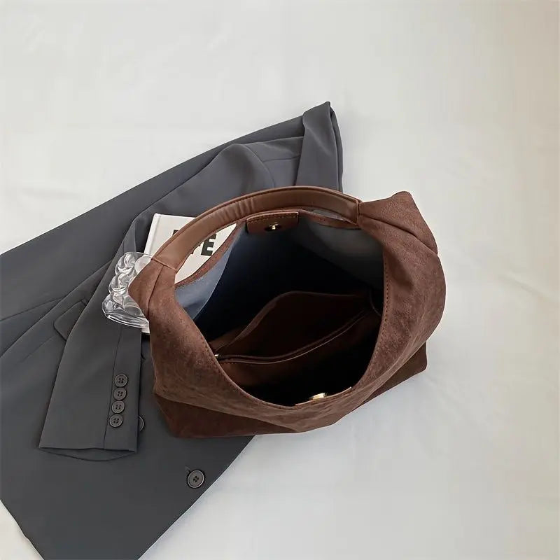 Side profile of the elegant women's suede shoulder bag, highlighting its slim design.