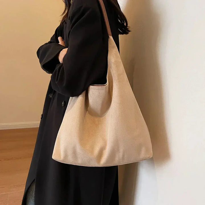 Fashionable suede shoulder bag for women, showcasing its sleek, minimalist silhouette.