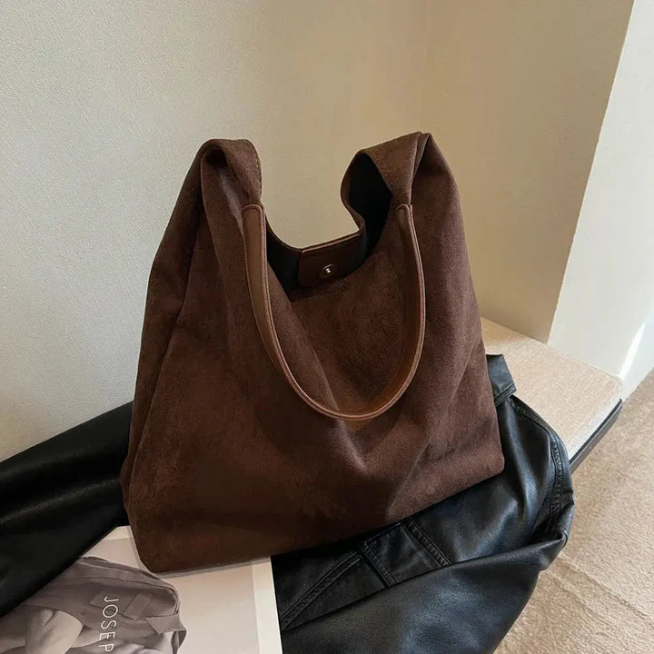 Detail of the comfortable shoulder strap on the versatile women's suede handbag.