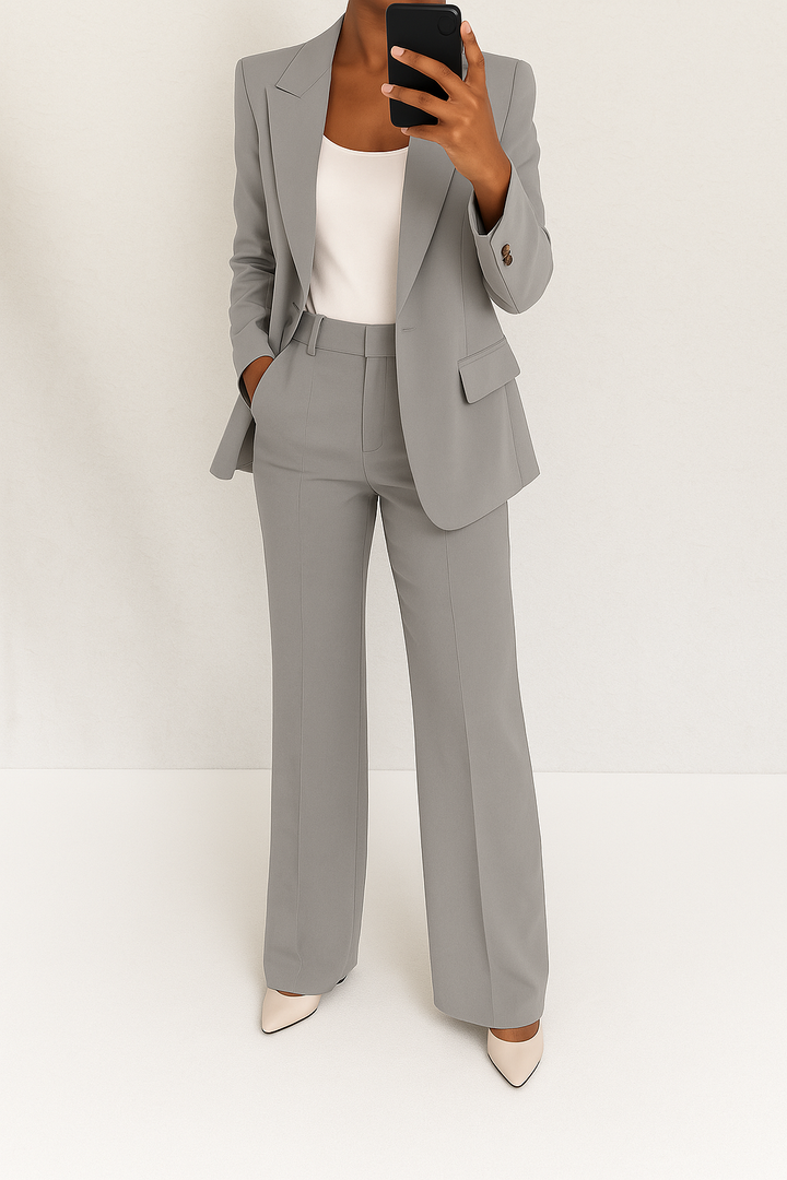 Professional women's two-piece suit with a classic tailored blazer and matching trousers.
