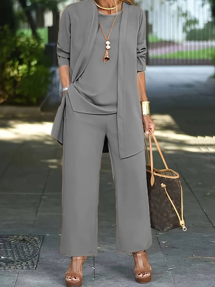 Professional women's three-piece pantsuit. Elegant business attire with long sleeve top, comfortable trousers & stylish jacket.