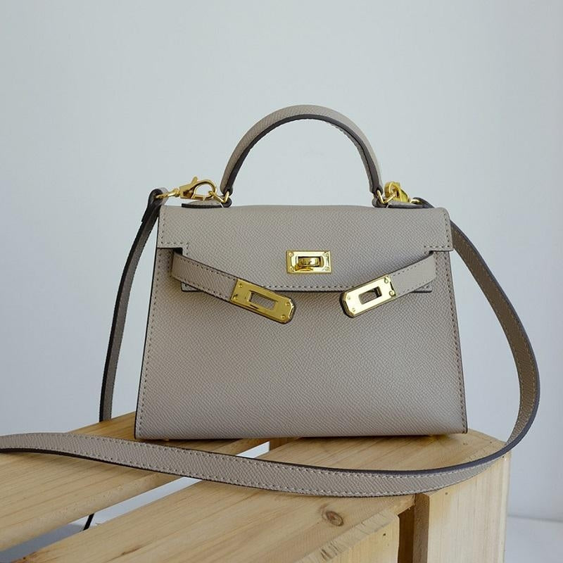 Structured women's top handle purse, featuring a bold gold lock, perfect for a polished look.