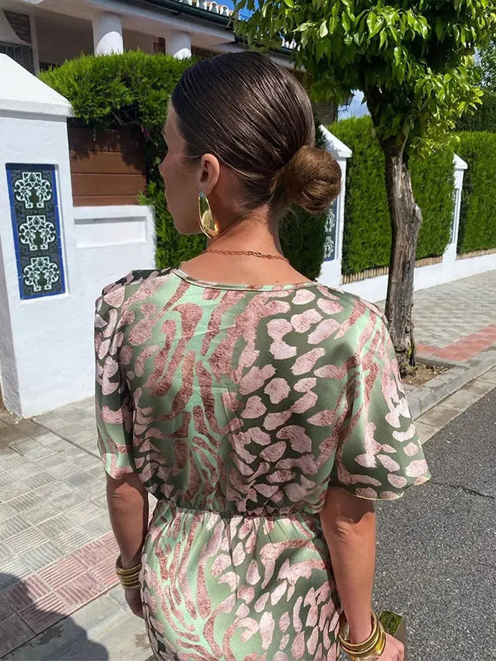 Flowy elegant women's midi dress with a stylish twist-front and v-neck, suitable for special occasions.