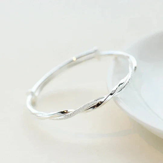 Stylish twisted silver cuff bracelet for women. Modern, stackable sterling silver jewelry, an elegant minimalist accessory.