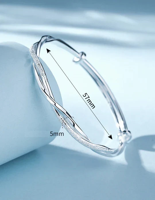 Shining women's silver twisted cuff bracelet. A versatile, elegant accessory with a minimalist design, great for layering.