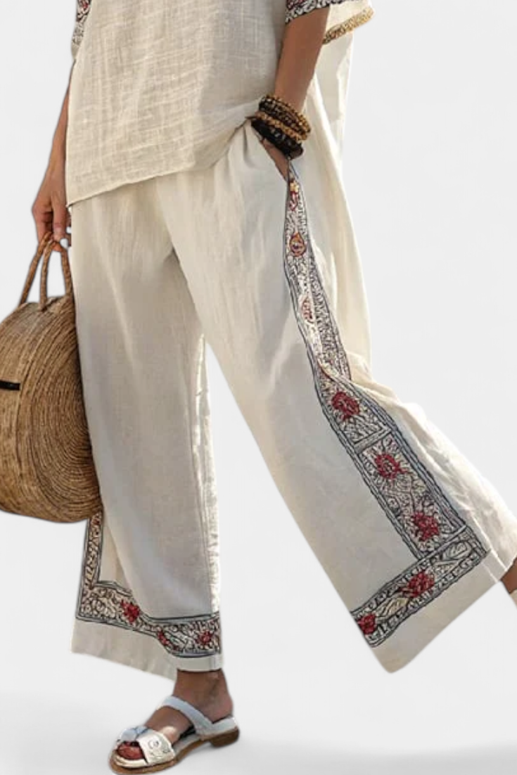 Boho chic women's set: a sleeveless blouse with intricate embroidery paired with flowy wide trousers. Ideal summer outfit.