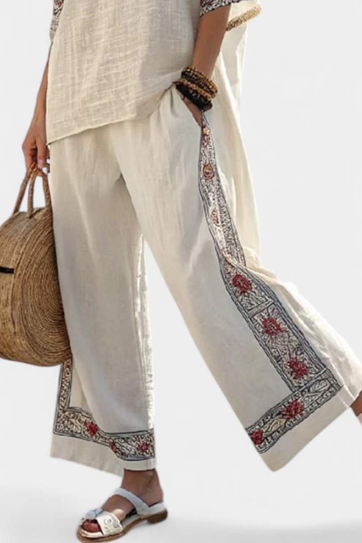Boho chic women's set: a sleeveless blouse with intricate embroidery paired with flowy wide trousers. Ideal summer outfit.