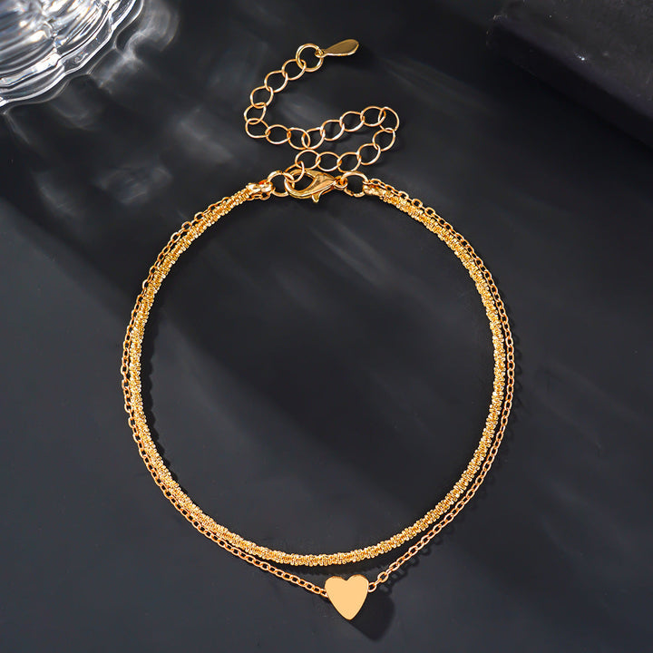 Stylish two-tone heart charm anklet for women, featuring a delicate silver & gold design, perfect elegant summer accessory.