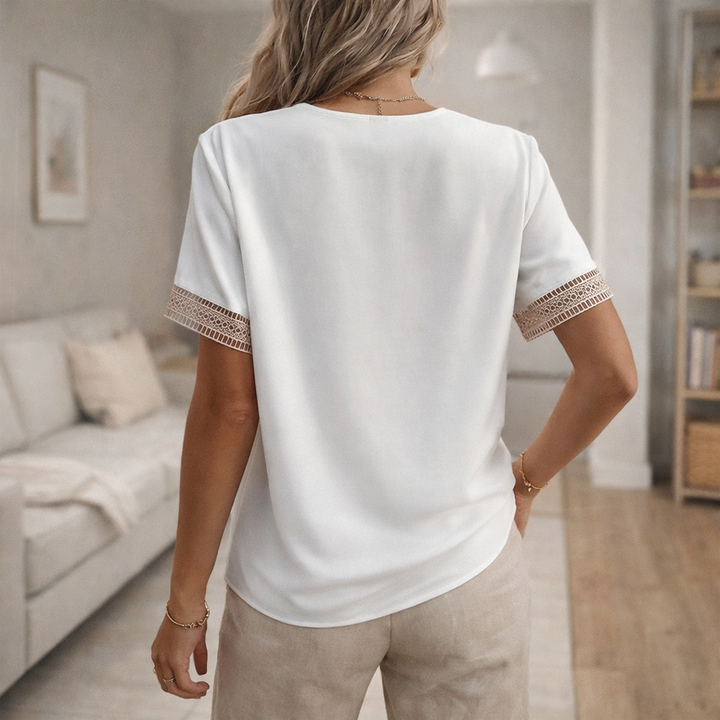 Comfortable women's relaxed fit V-neck blouse with elegant lace trim. Short sleeve top for warm weather fashion.