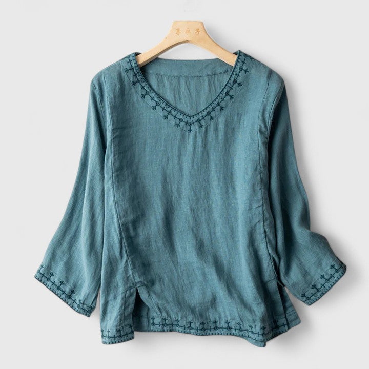 Elegant women's V-neck blouse with intricate embroidery. Perfect for casual chic or office wear.
