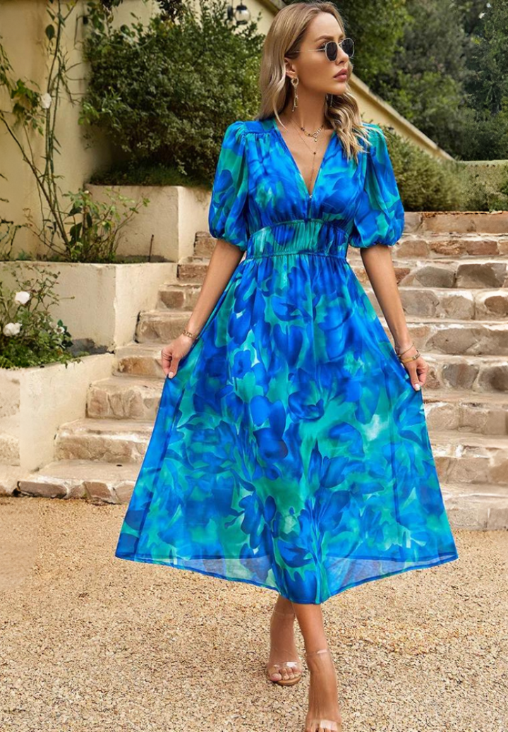 Close-up of the delicate floral print pattern on a women's V-neck A-line summer midi dress fabric.